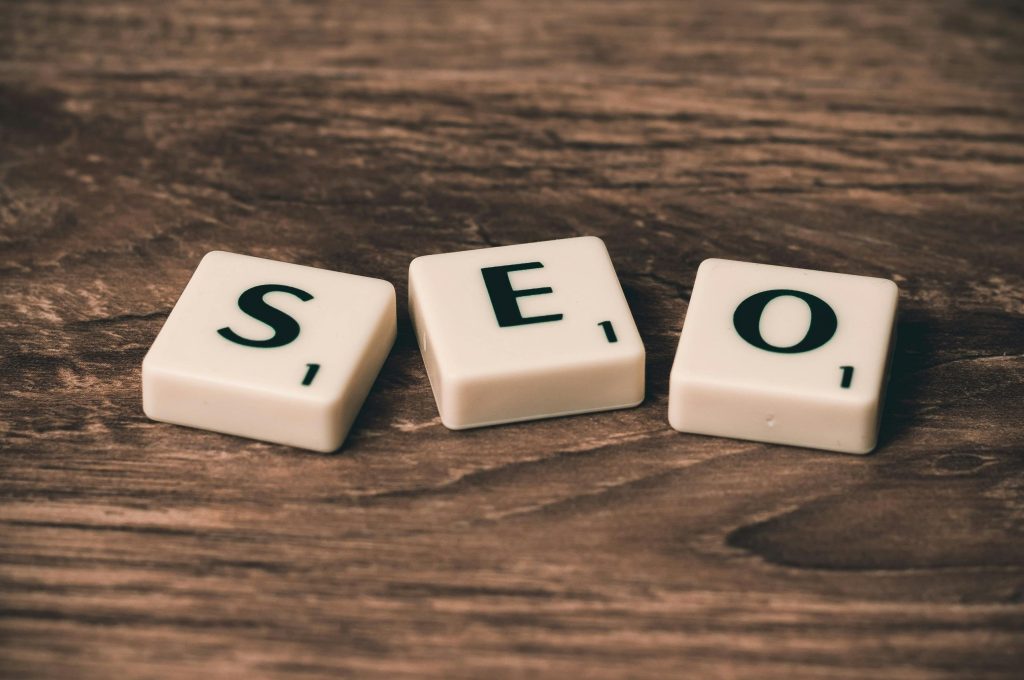 Current image: Scrabble tiles spelling 'SEO' on a wooden surface. Ideal for digital marketing themes.